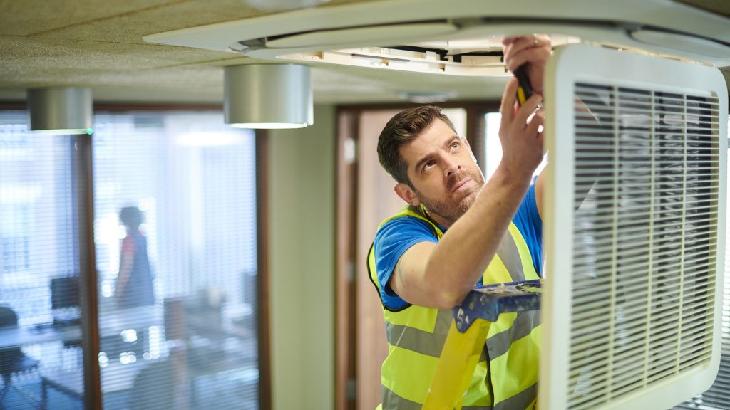 HVAC engineer performing air conditioning maintenance
