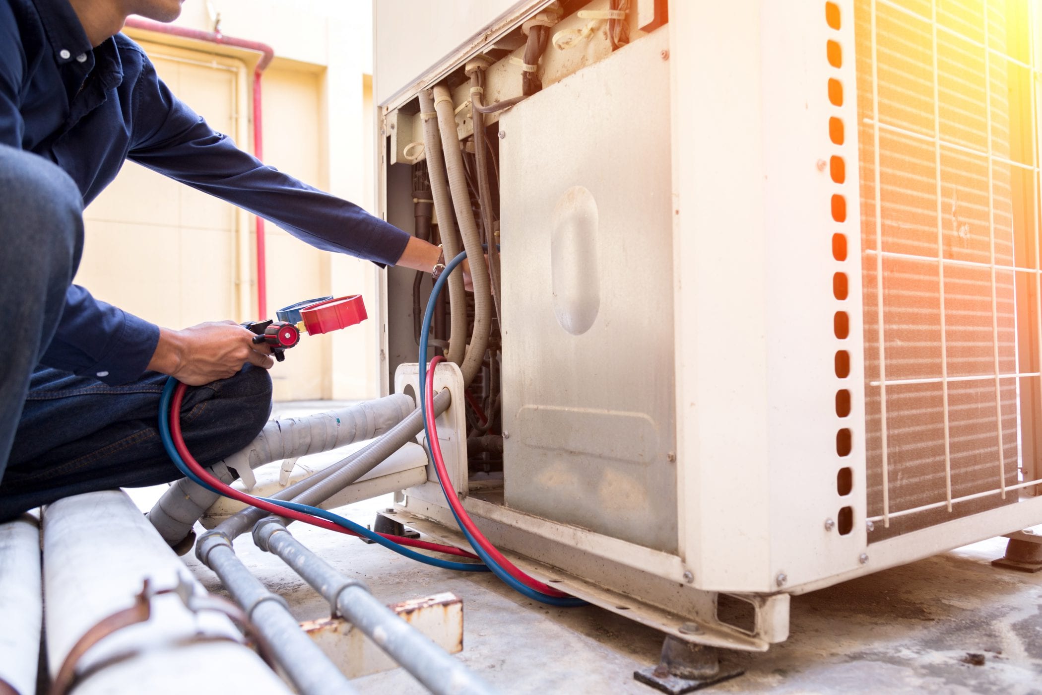Engineer servicing commercial warm air heating unit